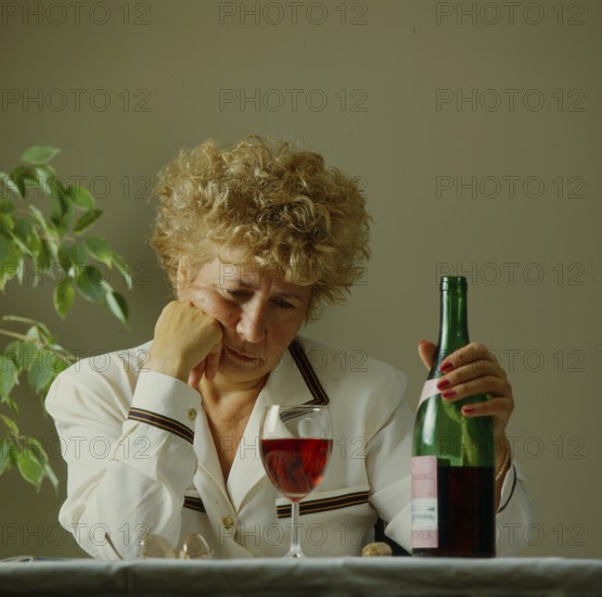 Older woman with wine glass and bottle
