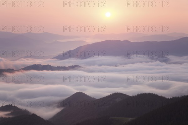 Sunrise over cloudy mountain ridge