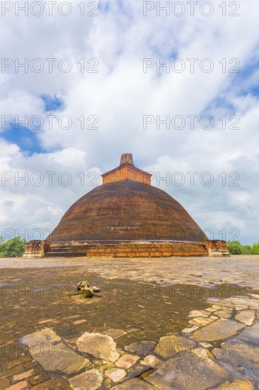 Jetavanaramaya Dagoba or stupa with damaged spire seen centered from platform corner in the ancient
