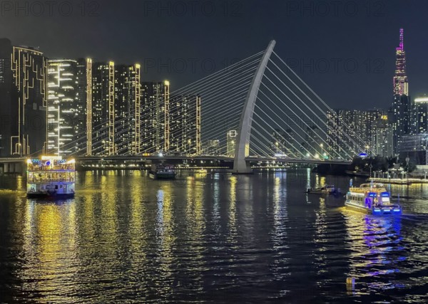Skyline Saigon, illuminated skyscrapers and bridge Cau Ba Son over the river Song Sai Gon at night,