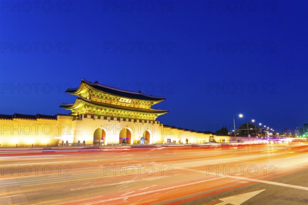 Long exposure streaking car tail lights leaving trailing light in front of Gwanghwamun main gate to