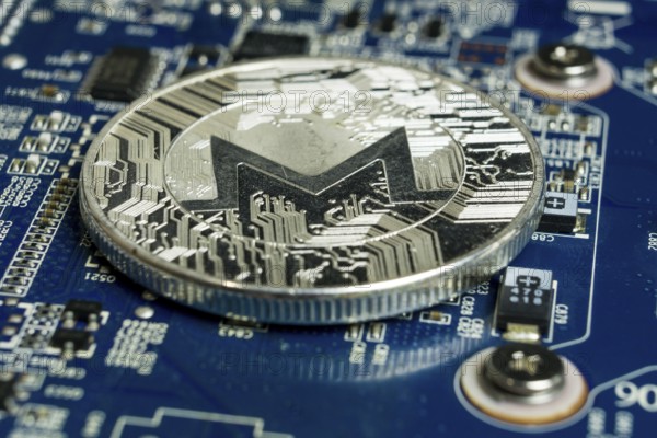 Photo of A single Monero coin on the blue computer motherboard