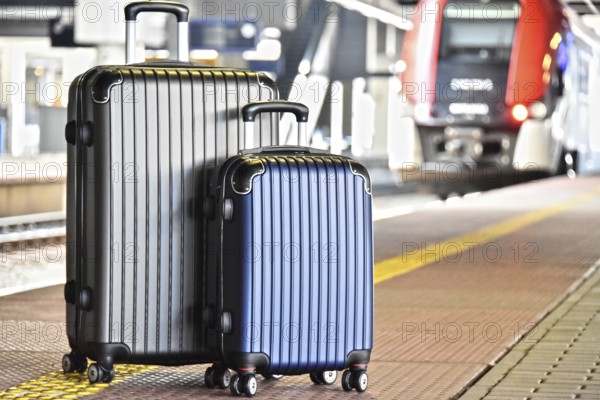 Two plastic travel suitcases on the railroad platform