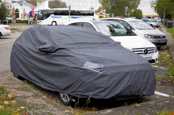 Mercedes, test vehicle covered with cover, parked at motorway service area