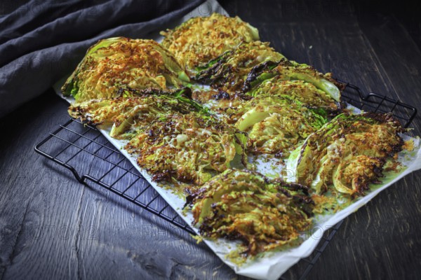 Baked savoy cabbage with parmesan cheese, honey and spices on baking sheet