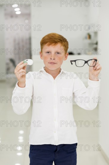 Boy holding plastic container contact lenses eyeglasses looking camera