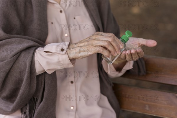 Older woman using hands sanitizer