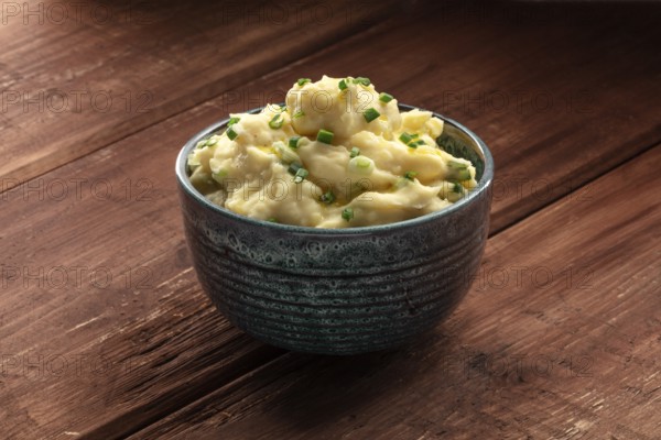 Pomme puree, a photo of a bowl of mashed potatoes with herbs on a dark rustic background with copy