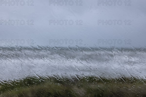 View of the stormy sea through raindrops on a window pane, Portbail, Cotentin, Manche, Normandy,