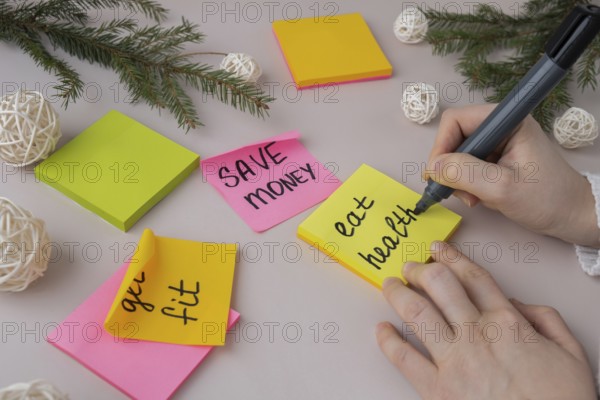 Woman writing promises and aims. Preparation for new year new life new me. Visualizing wish list