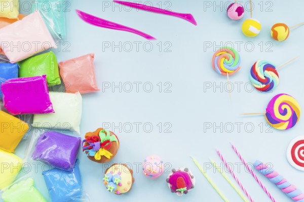Colorful clay plastic bag with fake cake lollipop blue background