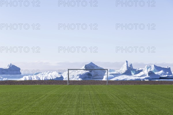 Qeqertarsuaq, Greenland, July 6, 2018: The soccer field with icebergs in the background, North