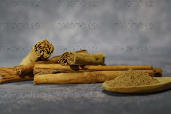 Cinnamon stick and ground cinnamon in a wooden spoon