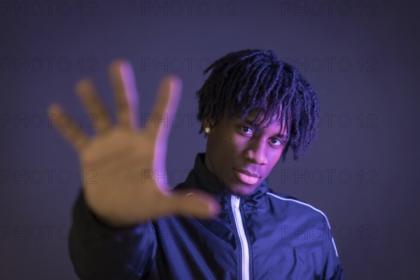 Black person doing the stop racism gesture on a black background
