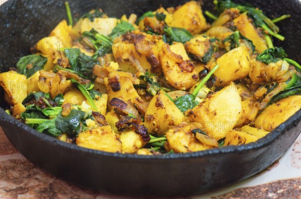 Saag Aloo, Indian style spinach and potato dish in cast iron pan