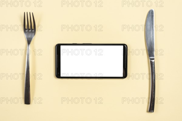 Smartphone stainless steel fork butterknife beige background