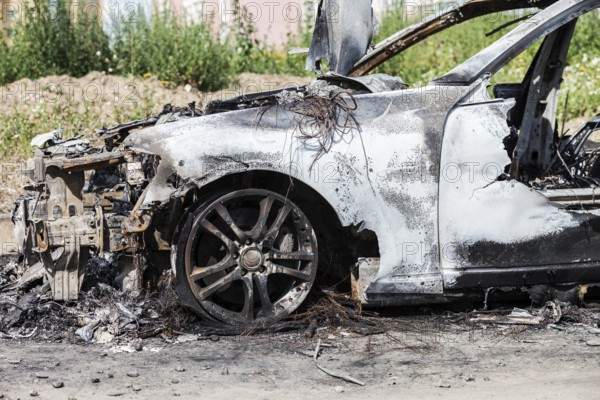 Road wreck accident or arson fire burnt wheel car vehicle junk