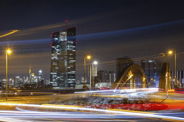 The lights of the European Central Bank (ECB) and the Frankfurt banking skyline glow in the