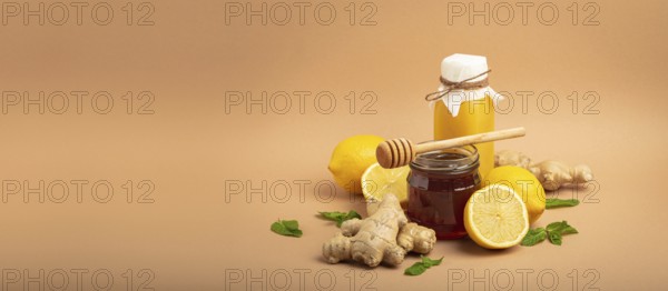 Composition with detox drink, sea buckthorn berries, lemons, mint, ginger, honey in glass jar. Food