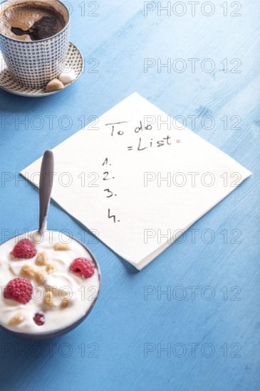 White napkin with a draft of a to do list, surrounded by a bowl of yogurt with cereal and raspberry