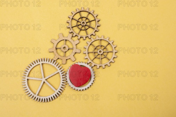 Heart shaped icon and Wooden cogwheels as love concepts