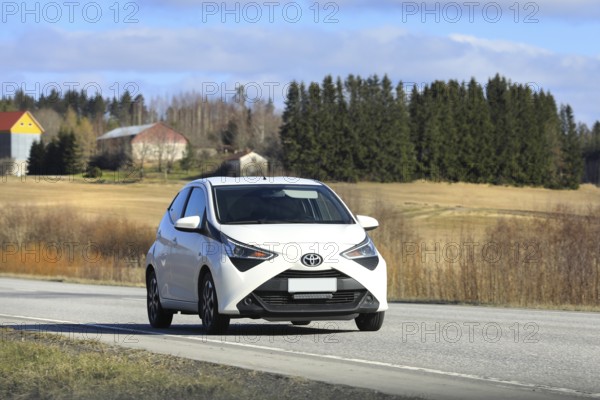 White Toyota Aygo city car, Second generation facelift model, at speed on highway. Salo, Finland.
