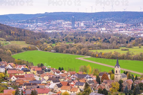 Village in the valley with Jena and wind turbines in the background, surrounded by autumnal