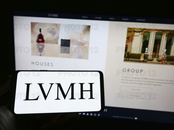 Stuttgart, Germany, 04-16-2023: Person holding mobile phone with logo of company LVMH Moet Hennessy