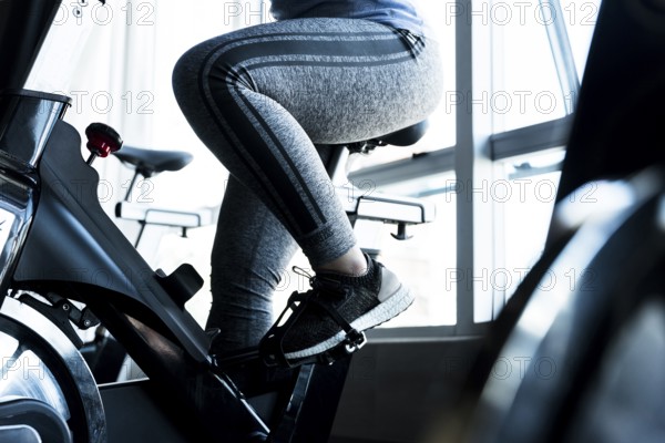 Fitness girl using stationary bike