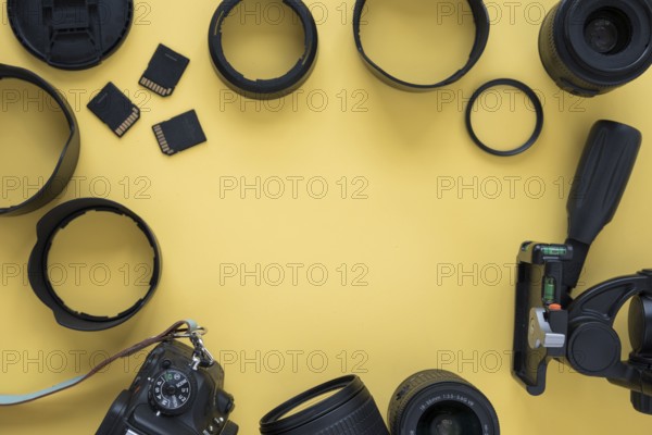 Professional dslr modern camera with camera accessories yellow background