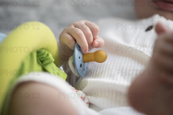 close-up view of hand of baby holding pacifier