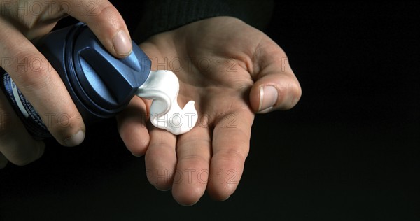Hand of Woman and shaving foam against Black Background