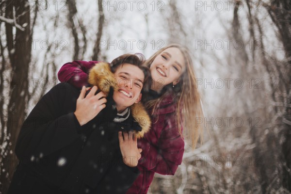 Beautiful young teen couple spending time together outside in cold winter. Happy and joyful people
