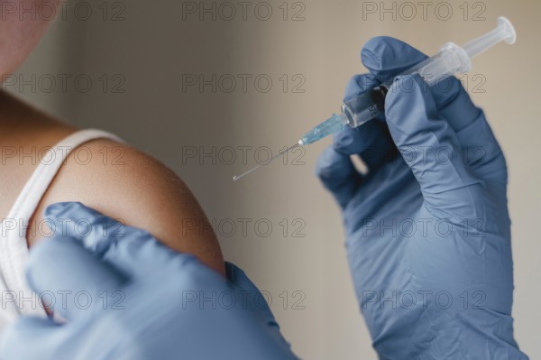Doctor with gloves administering little child vaccine