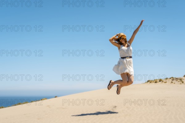 Happy woman jumping in a view point with sea views in Cabo de Gata, Spain, Europe
