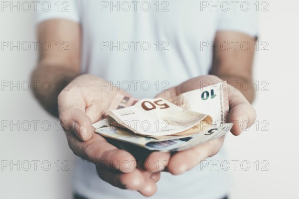close-up of hands of caucasian man offering or handing over money to someone else