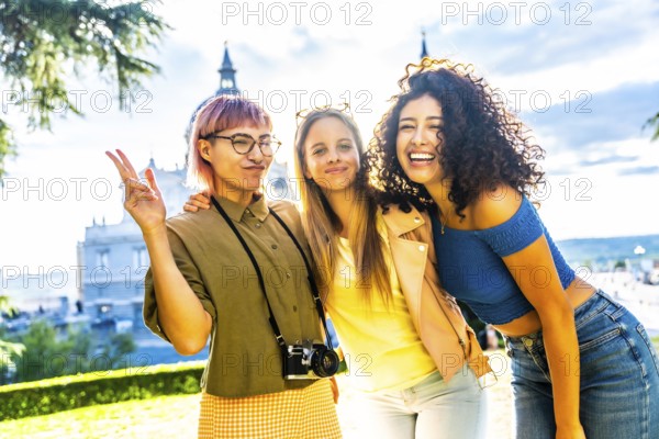 Happy female travelers gesturing success while standing in a city viewpoint in a park during sunet
