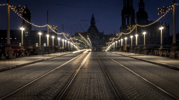 Dark, evening street view with light traces of a tram and illuminated architecture in the