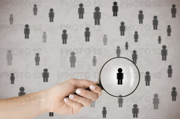 Concept of Human Resources selection. Hand holding loupe selecting a candidate