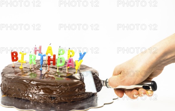 Female person cutting a homemade sacher chocolate cake with birthday candles