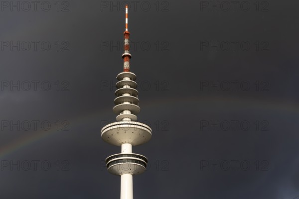 Weather symbol, Telemichel TV tower in front of a dramatic stormy sky with rainbow, Hamburg,