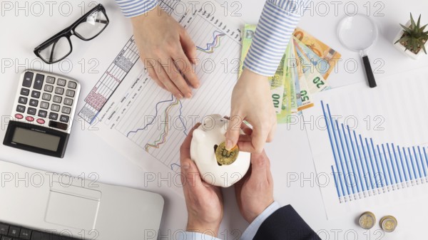 Person putting bitcoin piggy bank