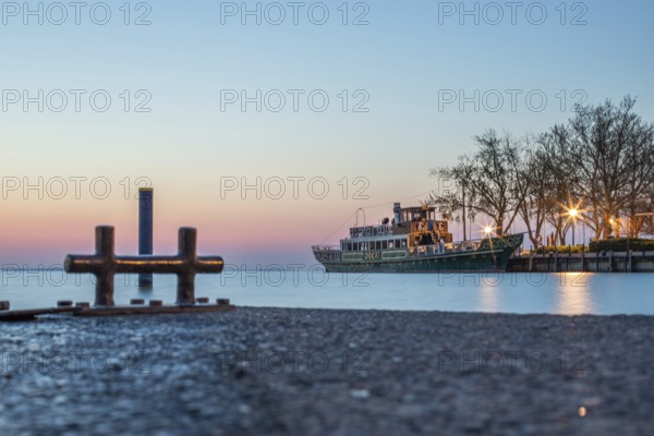 Sunrise on the shore and harbour of a lake in summer. Colourful sky with a wide view of the horiont