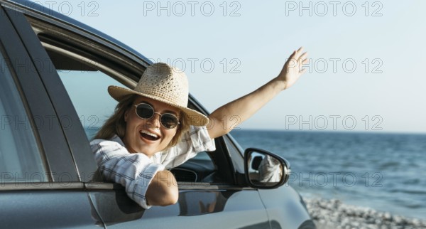 Happy blonde woman with hat looking out car window