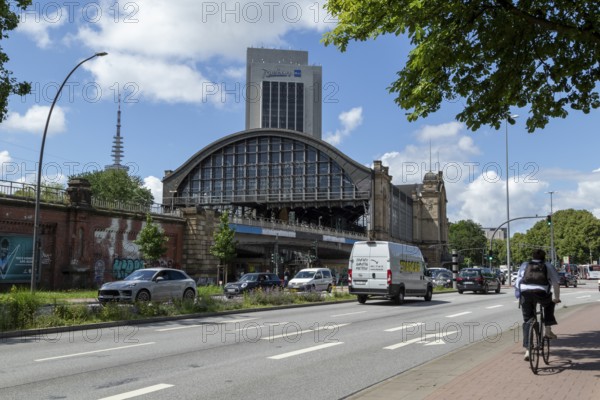 Traffic, cyclists and cars on the street at Dammtor railway station, behind them television tower