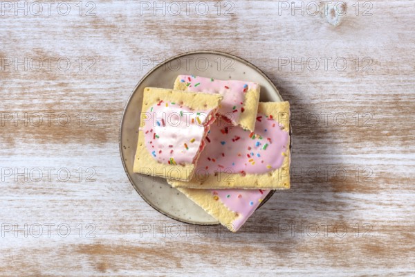 Strawberry pop tarts, shot from the top on a plate on a rustic wooden background