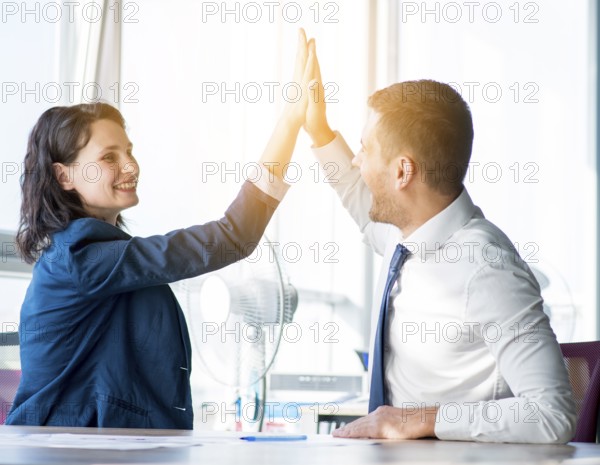 Two businesswoman businessman giving hi five office