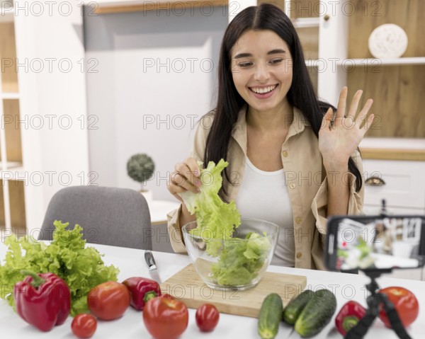 Female vlogging home with smartphone vegetables