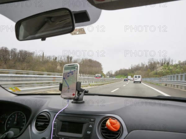 View from inside a car with a smartphone navigation setup driving on a highway, A1 A8 highway near