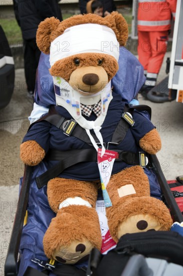 Injured teddy bear with full care sits on a rescue stretcher, police, open day, Berlin, Germany,
